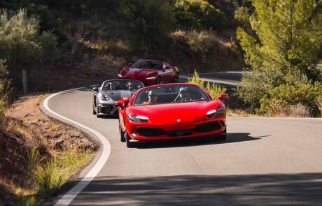 Caravana de superdeportivos trazando una curva en la carretera de la Sierra de los Tajos